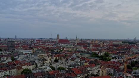 Stabilisierte-Drohnenaufnahme-Der-Münchener-Skyline-Und-Schaukel-Hinunter-Zur-Fließenden-Isar