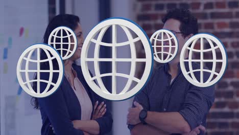 Animation-of-multiple-web-globe-icons-floating-against-diverse-man-and-woman-smiling-at-office