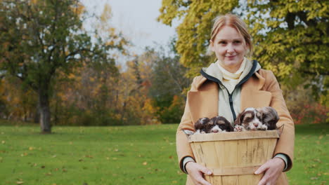 a woman holds a basket full of cute little puppies