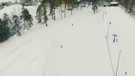 skiers-slide-on-track-at-ski-resort-on-mountain-upper-view