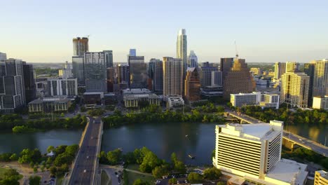 Luftaufnahme-Mit-Blick-Auf-Den-Fluss-Und-Die-Sonnenbeschienene-Skyline-Von-Austin,-USA-–-Verfolgung,-Drohnenaufnahme