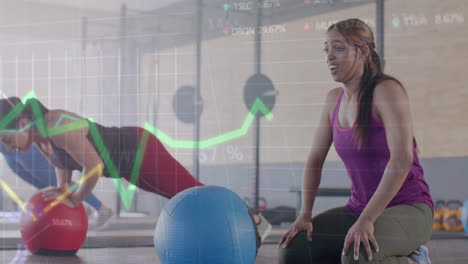 animación de datos en gráfico sobre diversas mujeres entrenamiento cruzado con bolas de medicina en el gimnasio