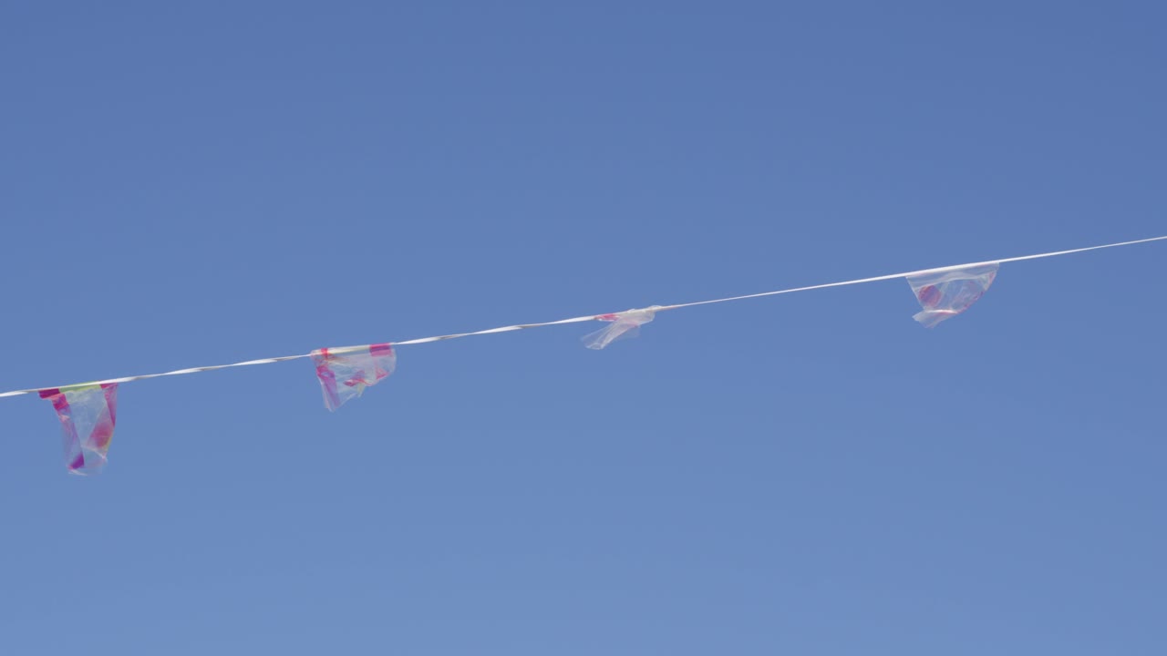 Red And White Paper Flags Hanging On A String Flapping With The Wind