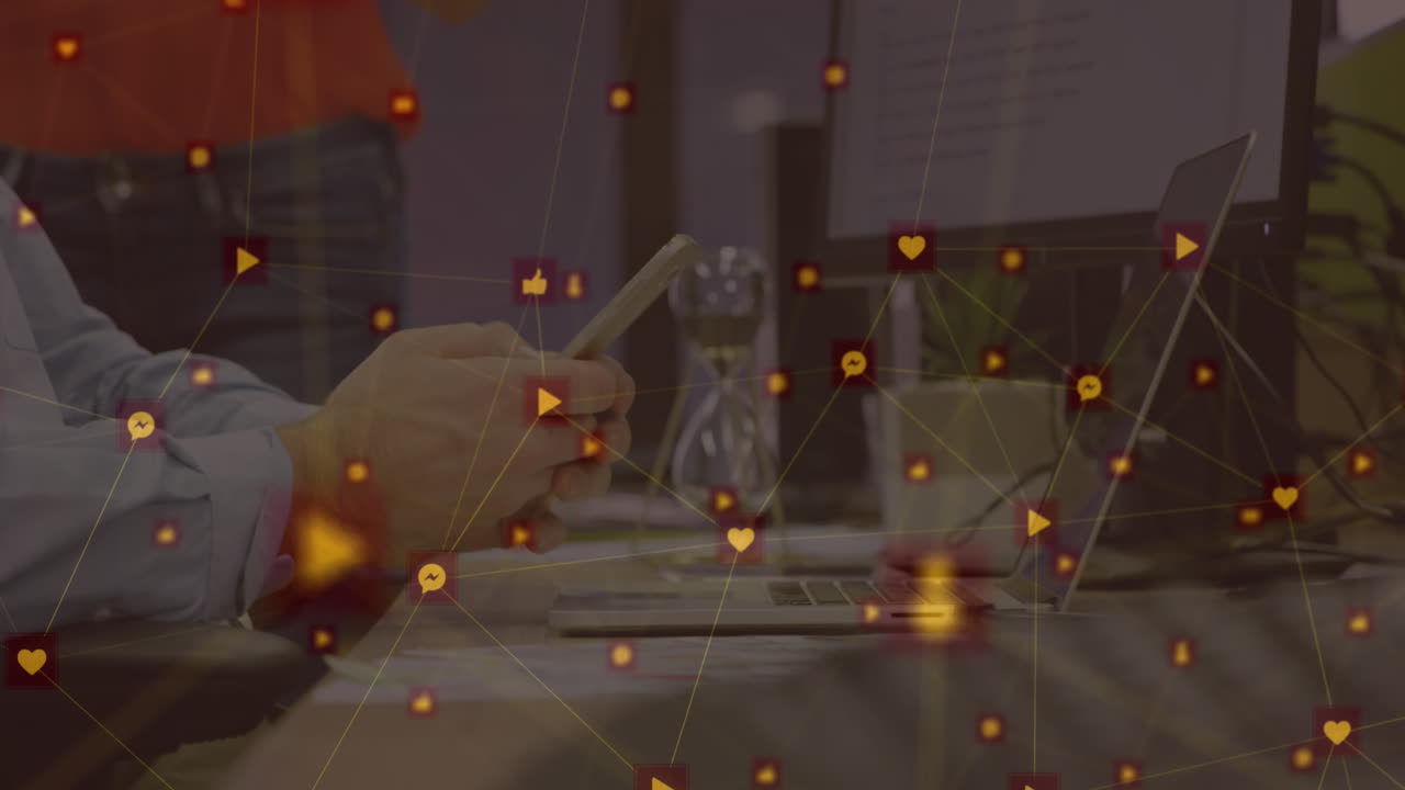 Animation of network of connections with icons over caucasian businessman using smartphone at office