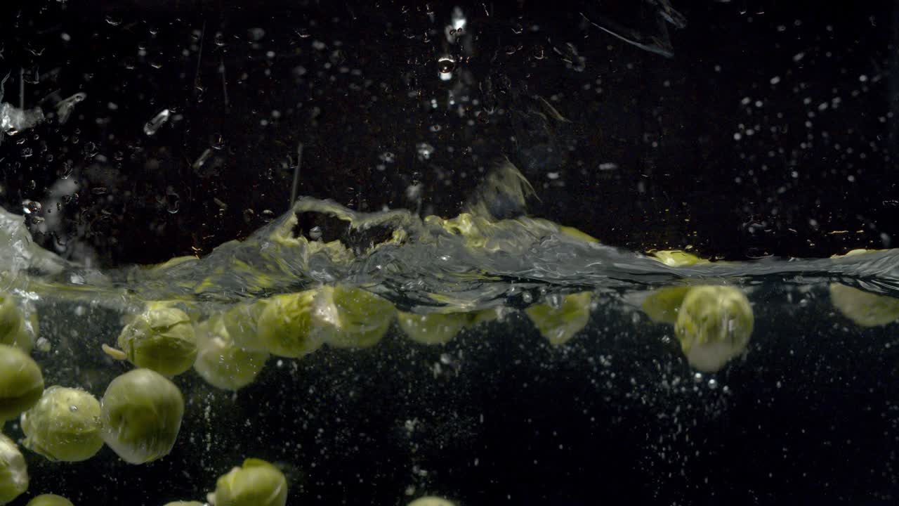 coles de bruselas cayendo en el agua con un salpico y burbujas