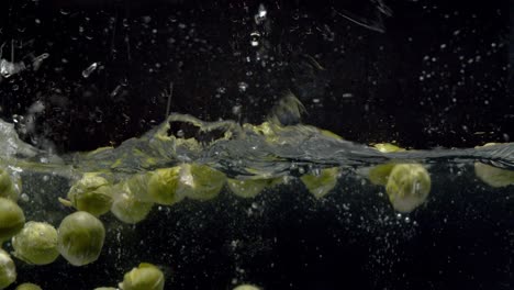 brussels sprouts falling into the water with a splash and bubbles