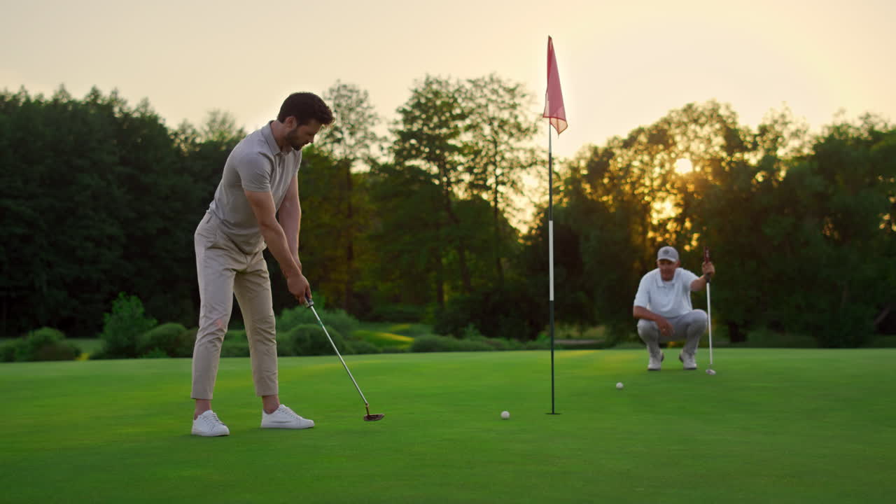 골퍼 팀이 선 ⁇  필드 코스에서 공을 때리고 있습니다. 두 명의 선수가 골프  ⁇ 을 놓치고 있습니다.