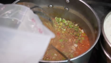 adding water to pot of simmering soup or stew