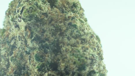 Macro-Close-up-shot-of-a-Marijuana-sativa-Super-Lemon-Amnesia-Haze-rock-flowers,-yellow,-green-and-purple-Kush,-on-a-360-rotating-stand,-in-a-black-shiny-bowl,-Slow-motion-4K-video