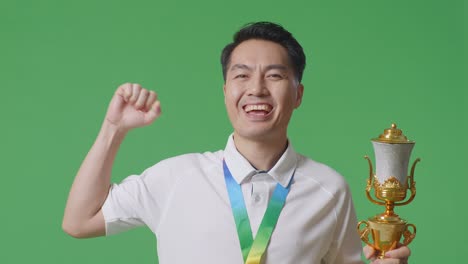 man celebrating a victory with a trophy and medal