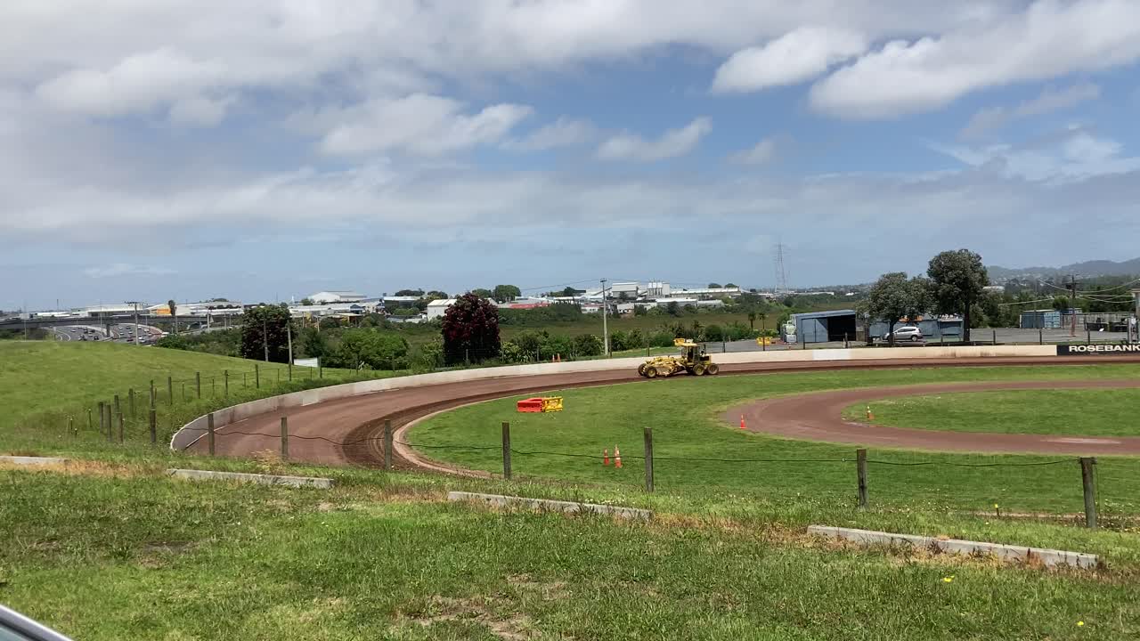 tractor amarillo trabajando a distancia en la pista de carreras
