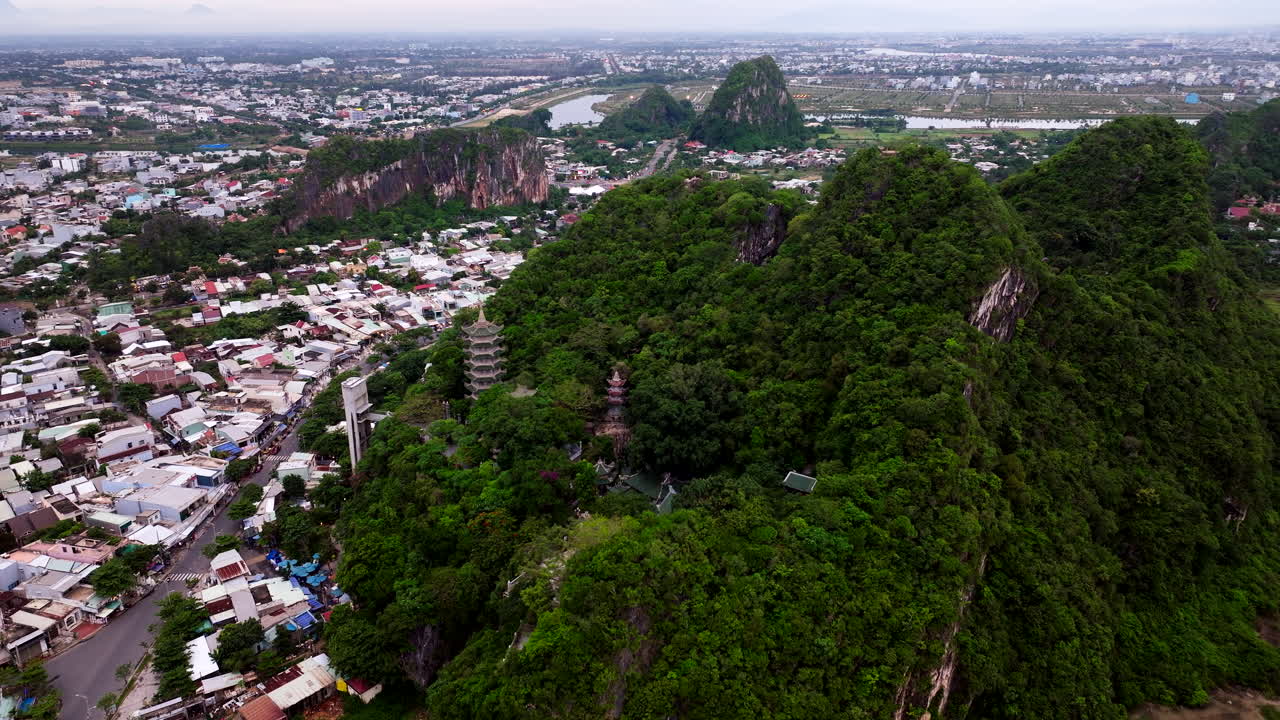 da nang, vietnam, asia - una vista expansiva de las montañas de mármol con el paisaje urbano que se desarrolla en el fondo - toma de un dron en órbita