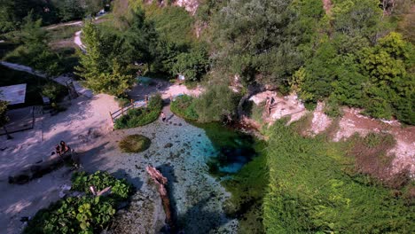 Diving-into-a-crystal-clear-source-of-Syri-i-Kalter-in-Albania,-Balkans,-tourists