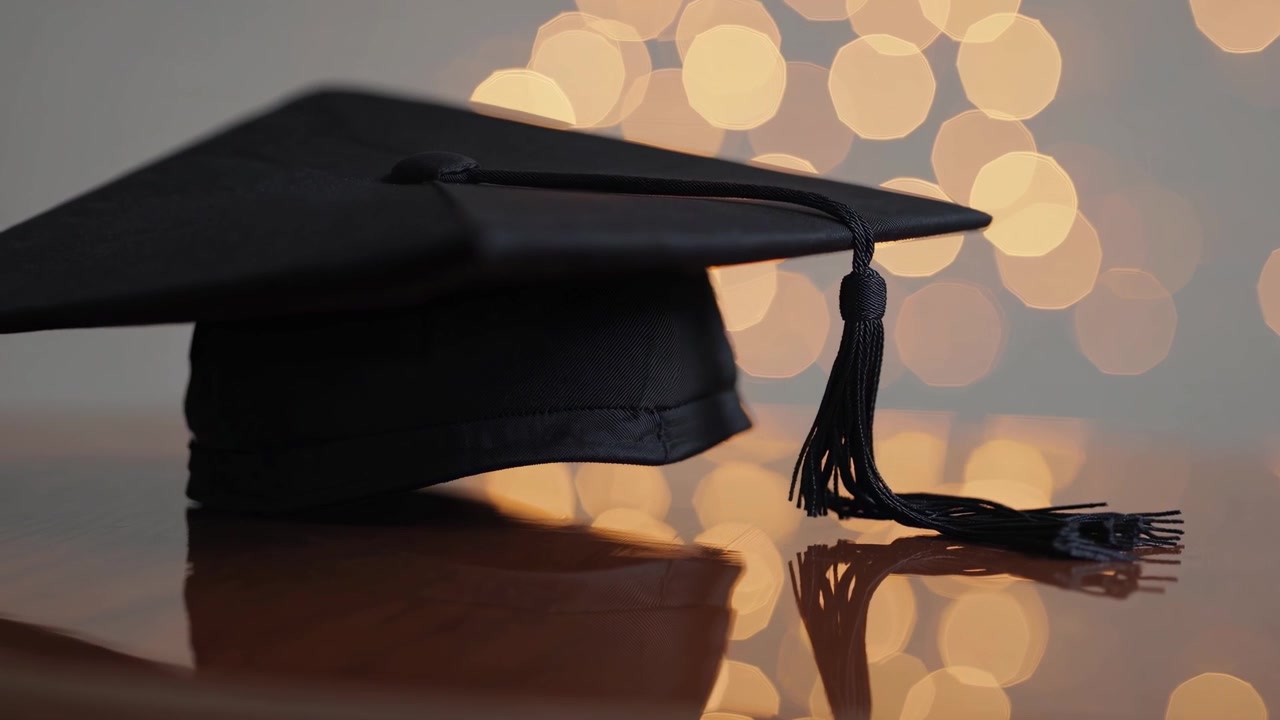 Capelo de formatura preto com borla contra luzes bokeh desfocadas
