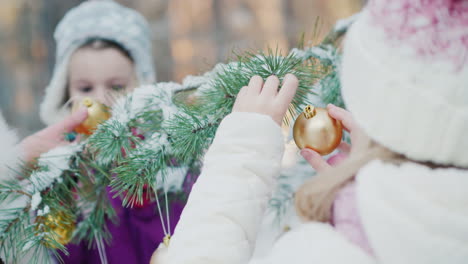 Two-Little-Girl-Friends-In-Warm-Clothes-Decorate-The-Tree-In-The-Courtyard-Of-The-House-White-Snow-L