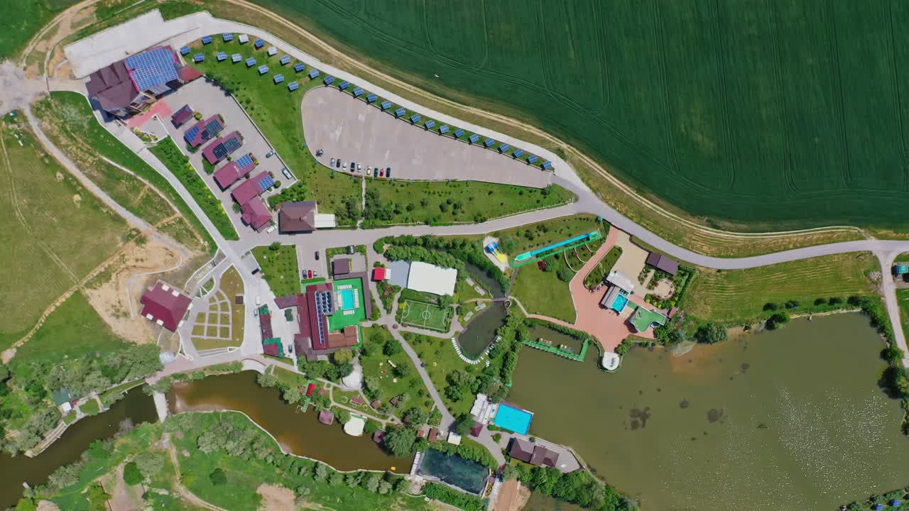 Modern resting zone. Panoramic view of a recreation complex surrounded by beautiful nature in summer. Aerial view. Camera moving around.