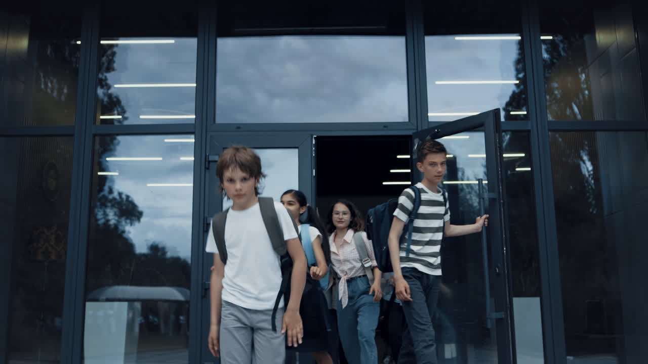 행복한 학교 아이들이 캠퍼스를 떠나고 학생들이 수업 후 자유를 즐기고 있습니다.