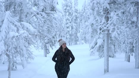 pretty girl exploring snowy winter wonderland in lapland, finland, arctic circle