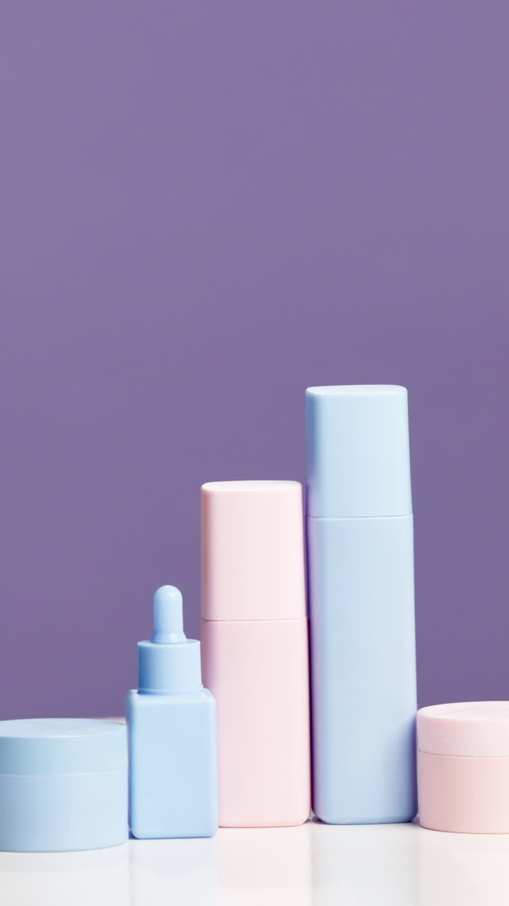 Prodotti per la cura della pelle color pastello su sfondo viola
