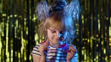 Trendy-stylish-girl-wears-pink-sunglasses,-looking-at-camera,-smiling-in-neon-light-at-disco-club