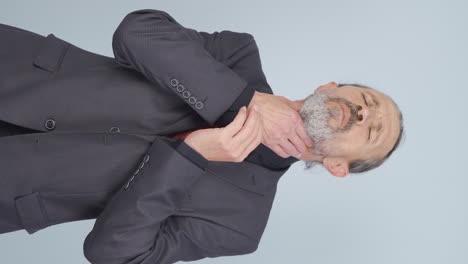 video vertical de un viejo hombre de negocios que sufre de dolor de garganta.