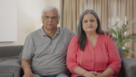 una pareja de ancianos indios frustrados mirando a la cámara.