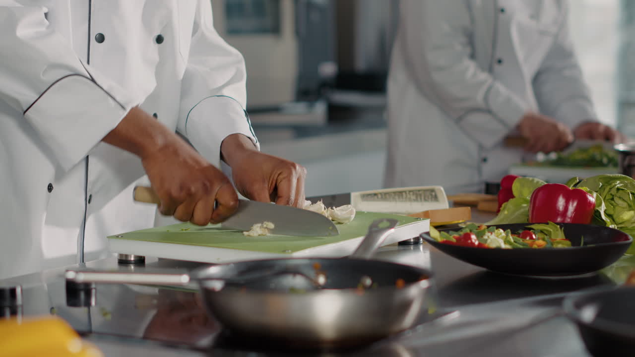 African american cook preparing garlic clove on cutting board