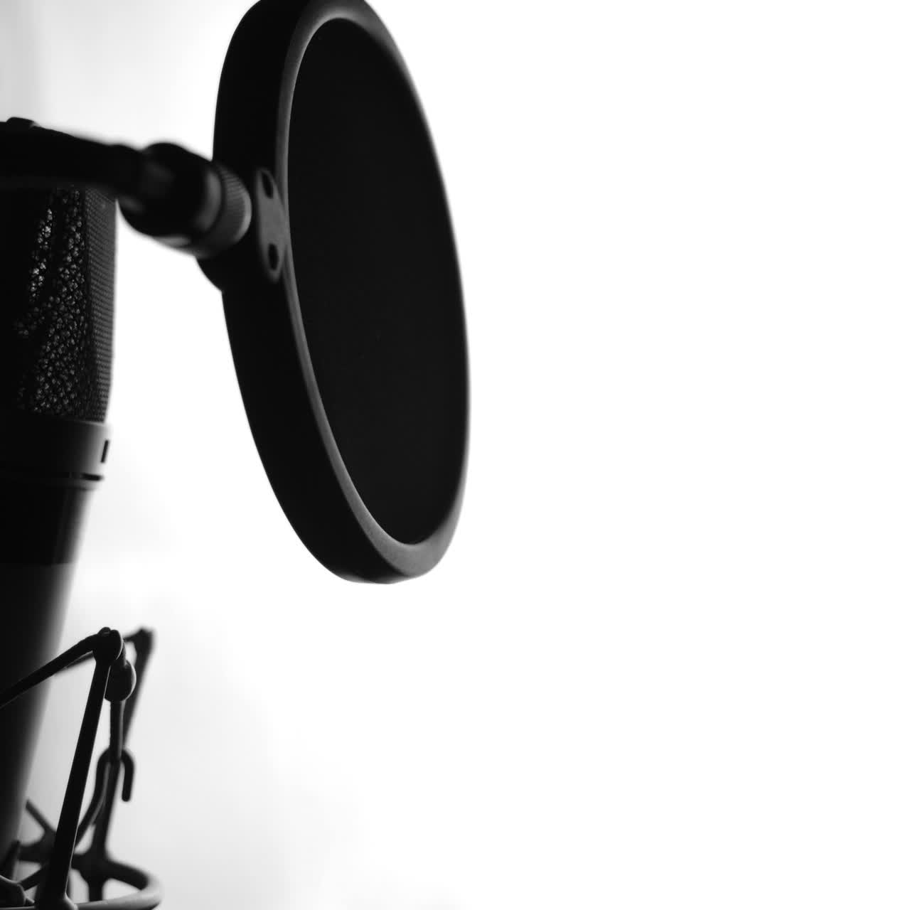 Side view of attractive female's face with perfect nose and pretty lips singing to the microphone. Singer standing in front of the mic and singing. Close-up. Black and white