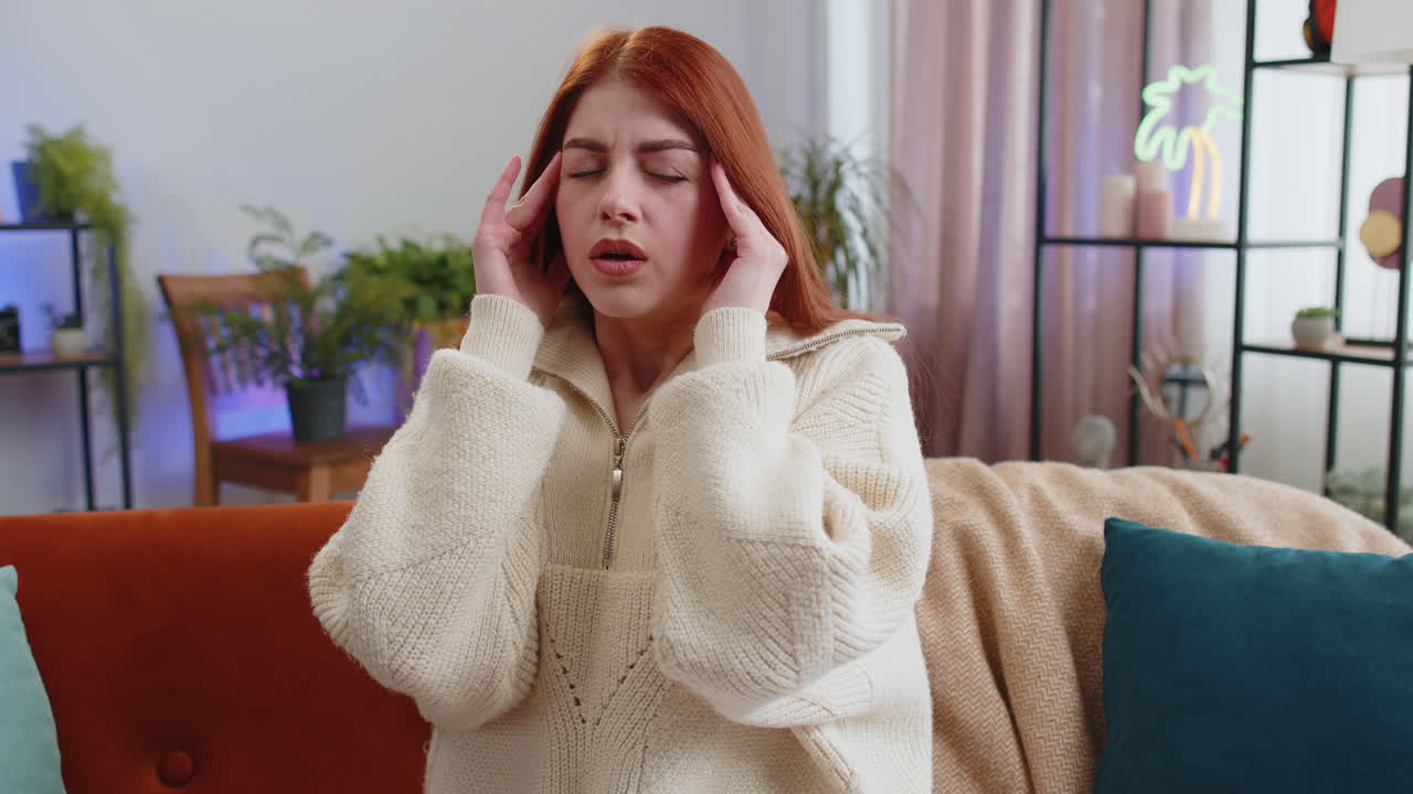 Displeased young woman rubbing temples to cure headache problem suffering from migraine stress