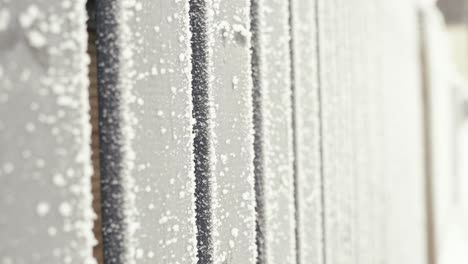 hoarfrost on wooden boards in closeup, abstract winter background, vertical