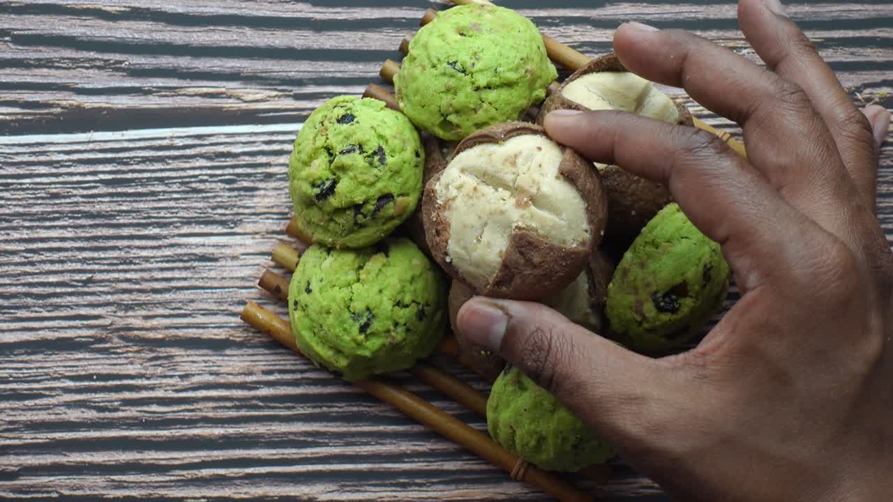 la mano alcanzando las galletas en una bandeja de madera