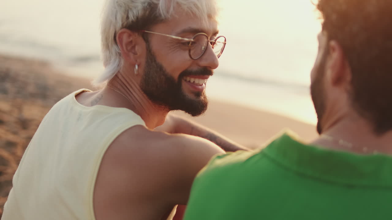 Due uomini si godono il tramonto sulla spiaggia