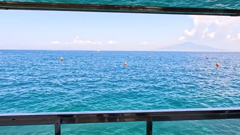 calm sea with distant swimmers and mountains