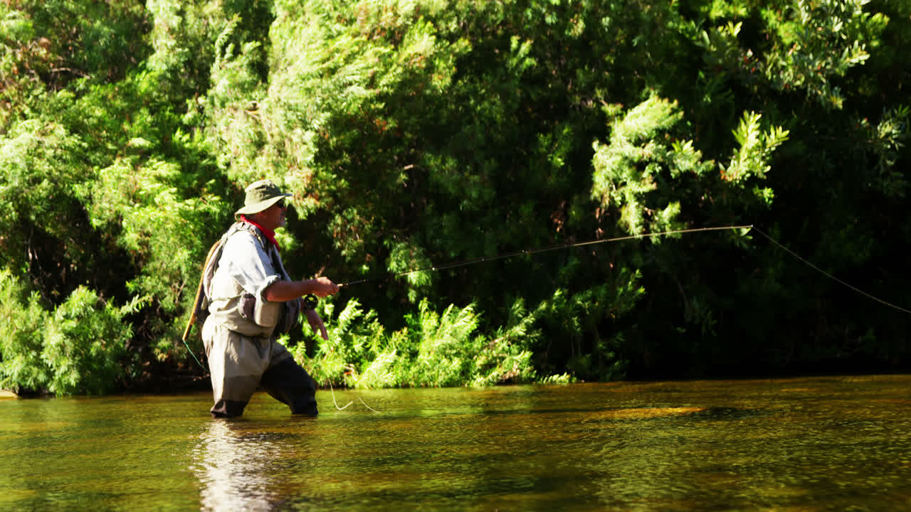 Pria memancing lalat di sungai.