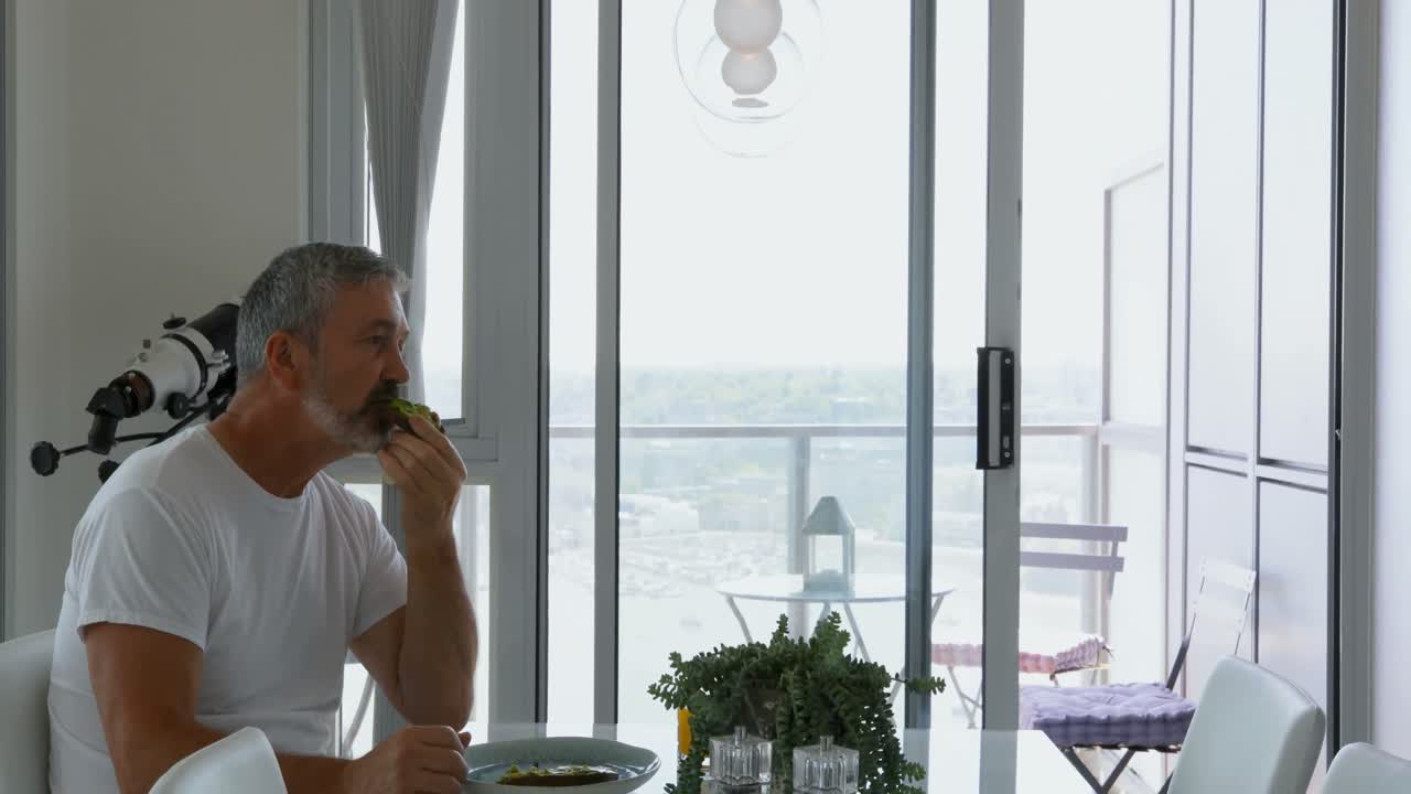 hombre comiendo el desayuno en la mesa en casa 4k