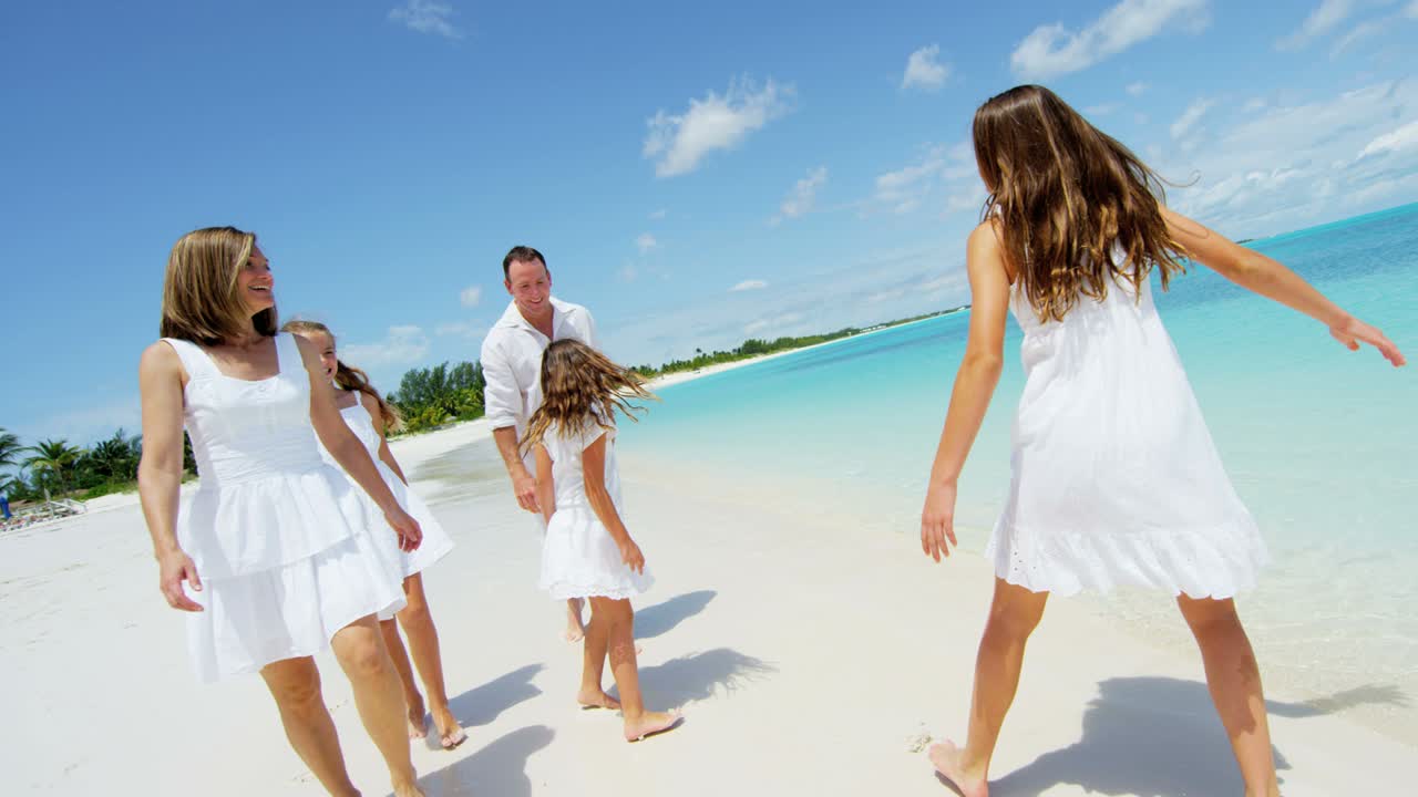 Caucasian parents and their young daughters on beach