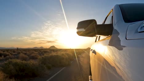 driving east as the sun sets in the west in the mojave desert's barren wasteland