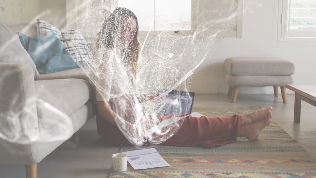 Женщина изучает диаграмму, сидя на ковре, а от ноутбука исходят искрящиеся частицы света, кружащиеся вокруг анализа данных