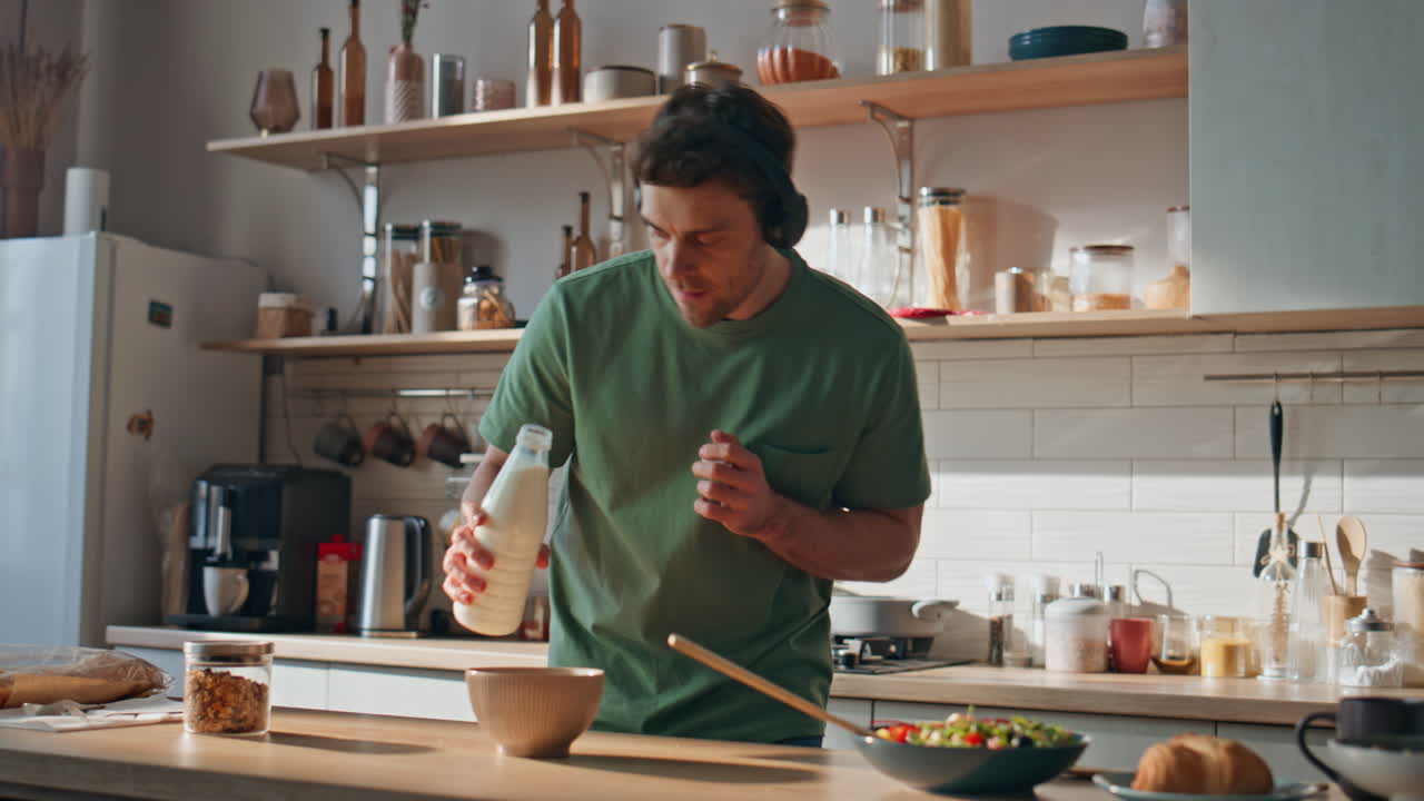 Earphones hipster preparing breakfast dancing at kitchen closeup. Guy singing