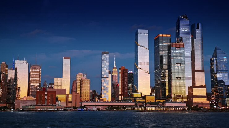 Nova York, EUA, 2 de outubro de 2025: Exteriores de edifícios altos e arranha-céus no horizonte de Nova York. Vista de baixo ângulo da paisagem urbana a partir da paisagem fluvial ao pôr do sol.