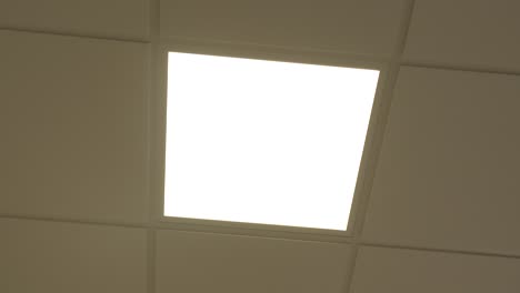 modern-led-light-panel-turns-on-in-slow-motion,-closeup-of-light-turning-on