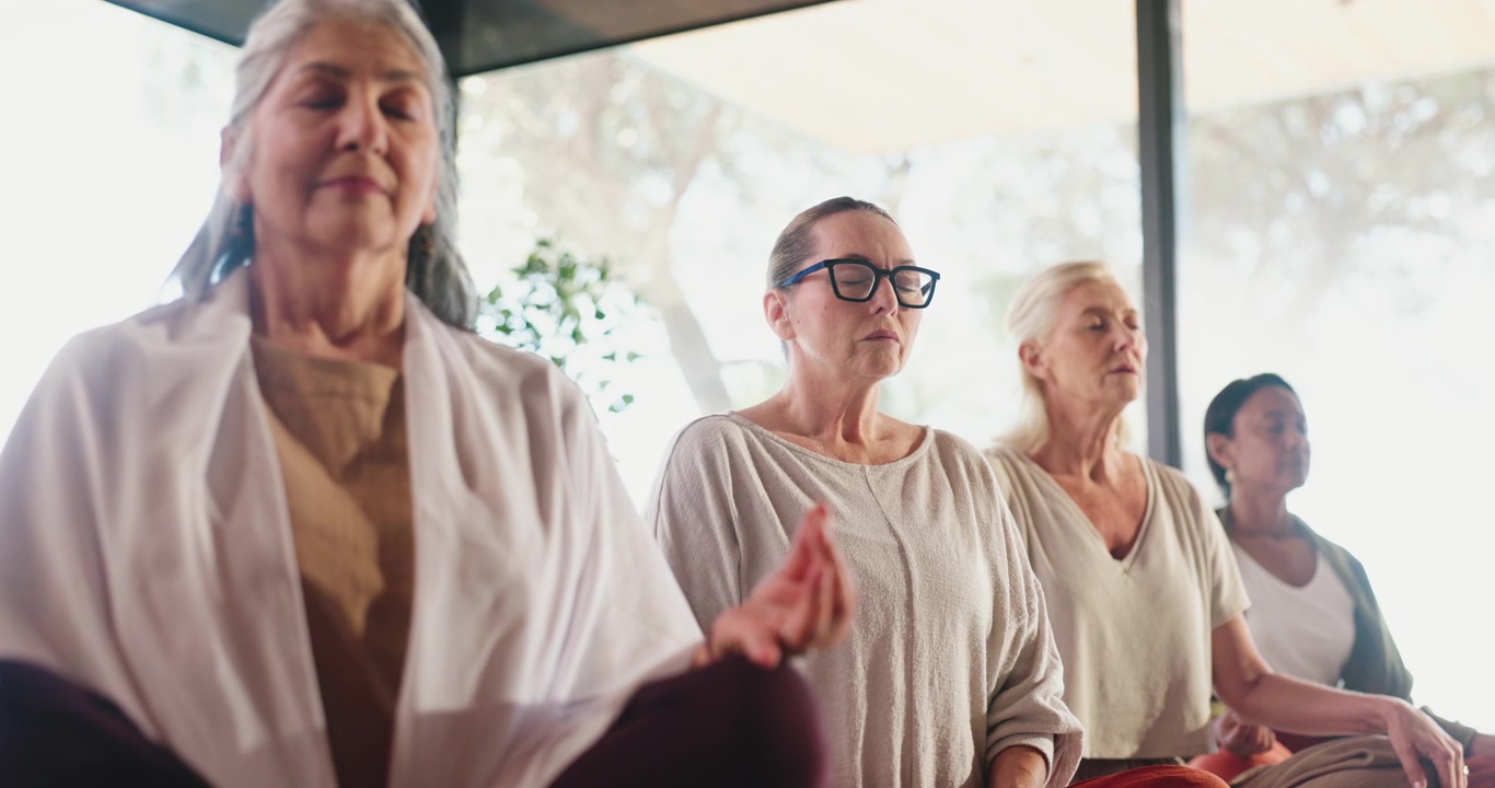Gruppe af Modne Kvinder der Praktiserer Meditation i et Lyst Studie