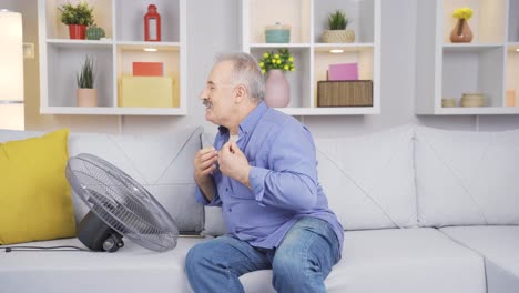 el viejo se enfría con un ventilador debido a la temperatura del aire.