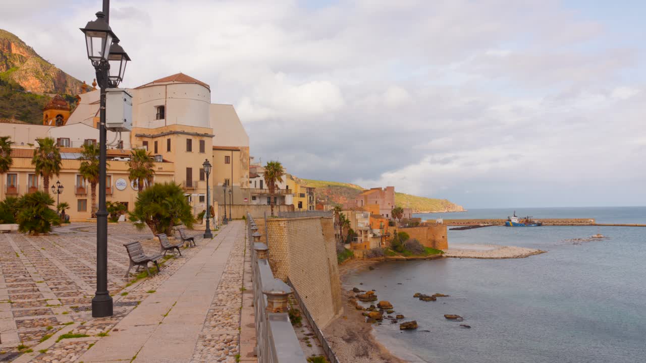 Charming architecture lines a picturesque waterfront as soft waves lap against the shore.