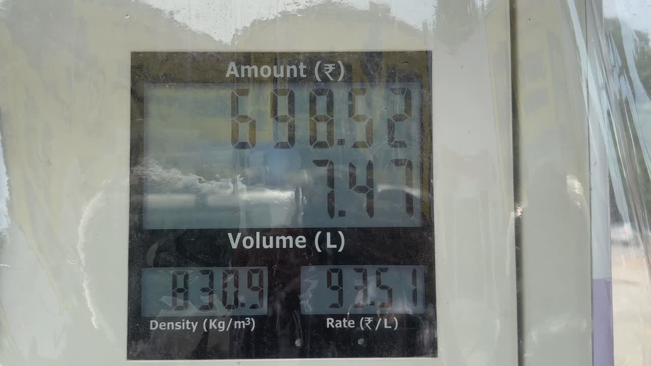 closeup of petrol pump display unit showing prices in rupee with moving numbers