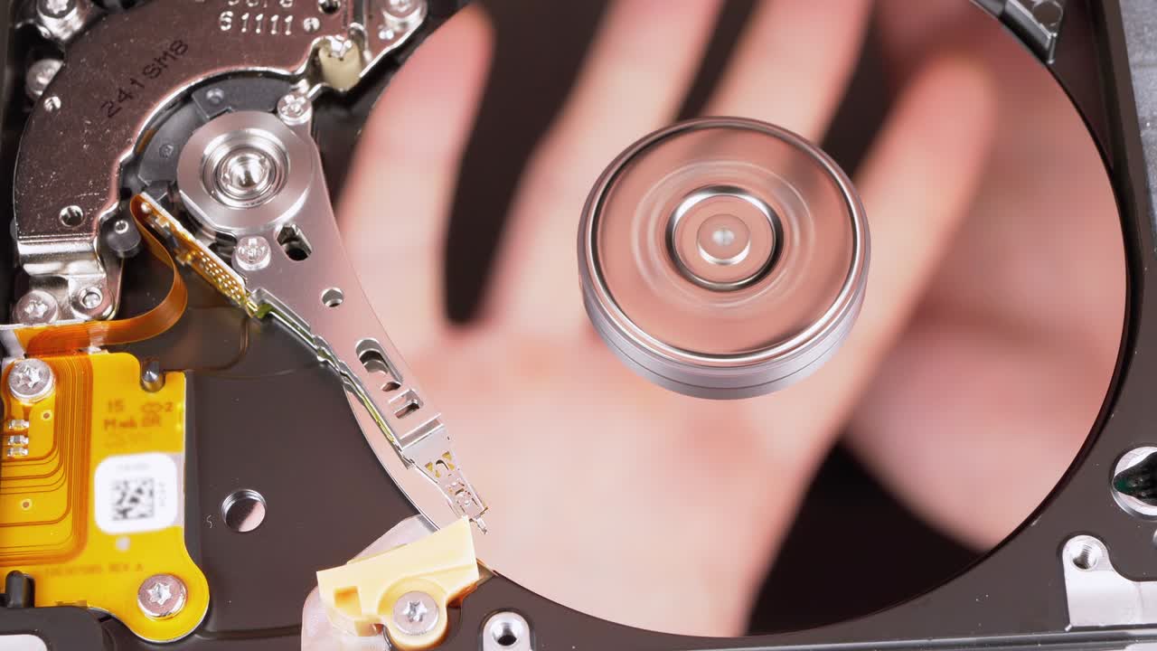 unidad de disco duro en el interior. reflejo de las palmas de las manos en la superficie del espejo de un disco magnético