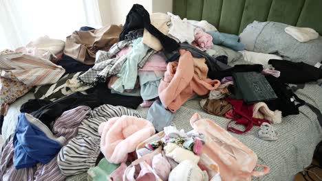 a bed covered in a pile of clothes