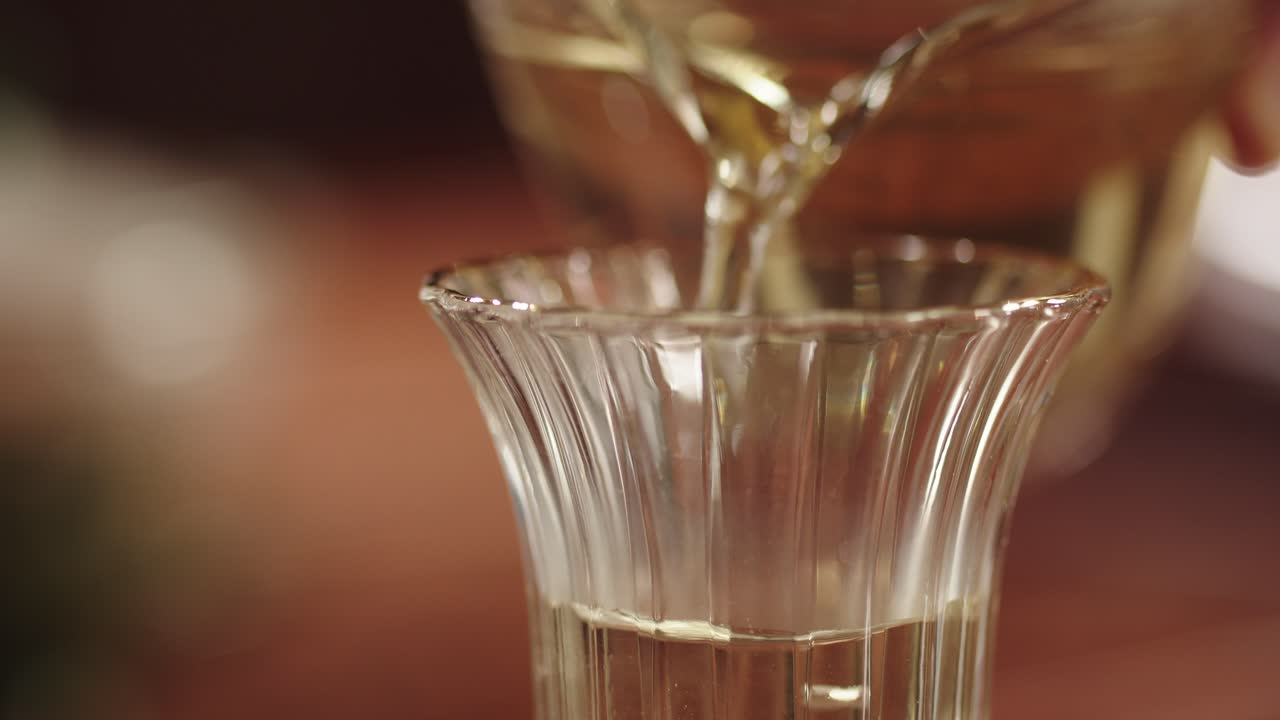 verter té verde en un vaso decorativo