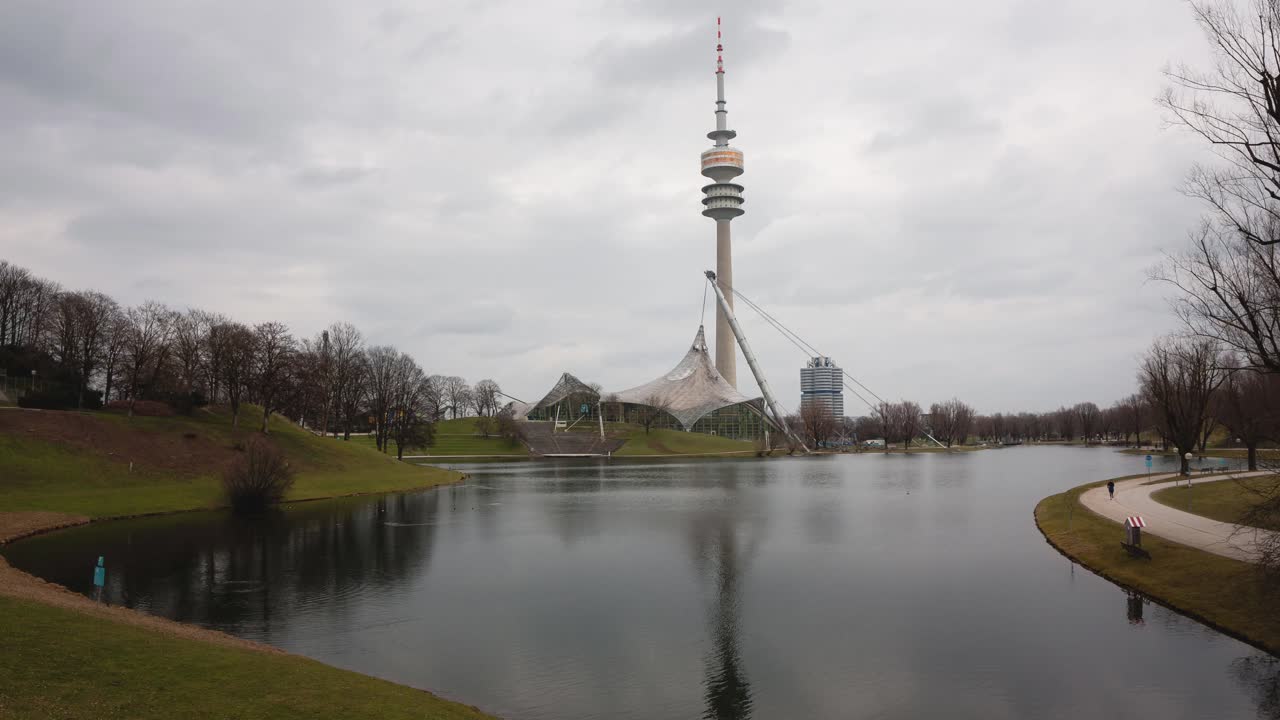 A unique timelapse shot of the Olympic Stadium in Munich from a different angle, showcasing the iconic structure under the dramatic, cloudy sky.