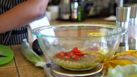 adding cut tomatoes to the olive oil, vinegar, and shallot dressing for a chopped salad - antipasto salad series